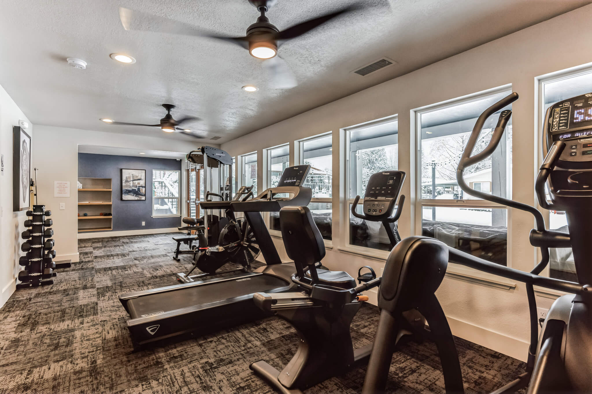 Manufactured homes community fitness center with glass window and quality gym equipment.